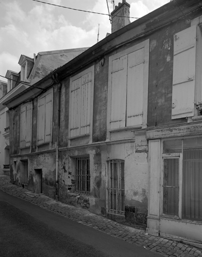 Vue de la façade sur la rue avec la boutique au premier plan.