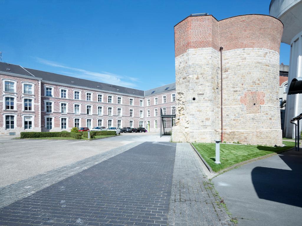 Vue générale de l'ouest de la tour, prise depuis la cour du lycée. La bande sombre au sol représente le tracé des anciens remparts auxquels était accolée la tour.