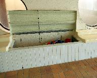 Détail des bancs aménagés le long des murs-pignons, qui servent également de rangement.