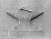 ALBERT, cimetière communal. Bas-relief latéral droit : une enclume, symbole des activités industrielles et artisanales de la commune.